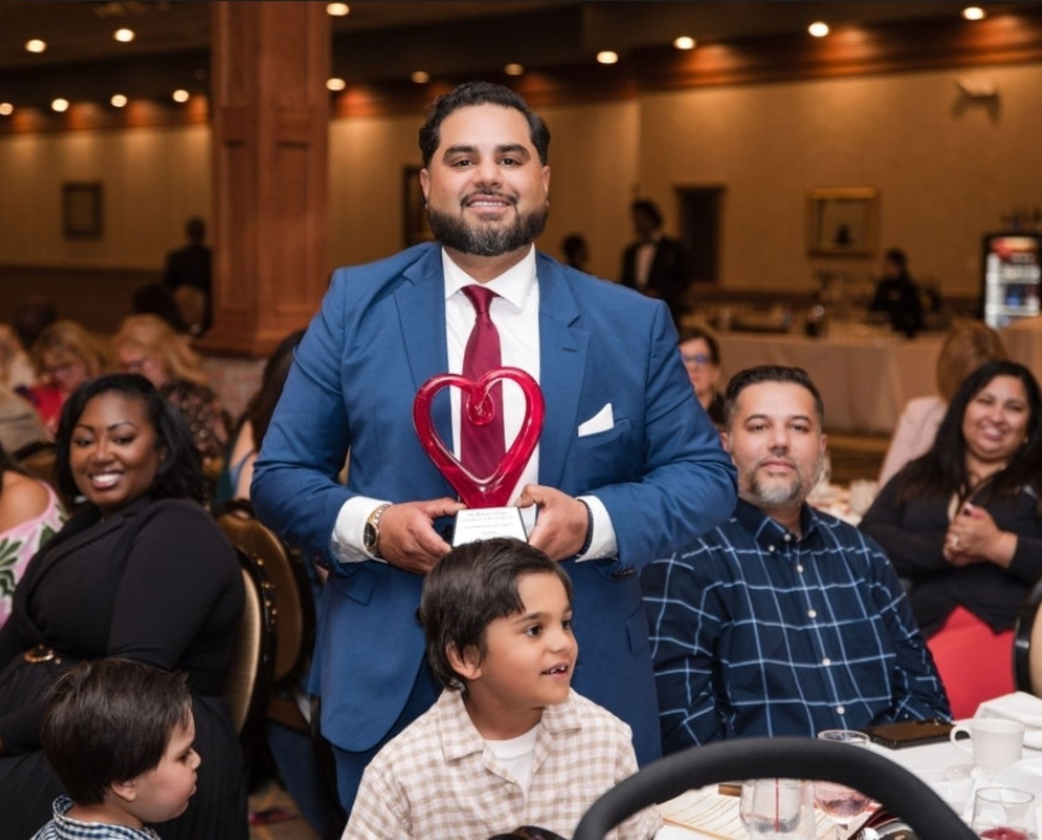 Zaid Baig holding an Outstanding Business Award